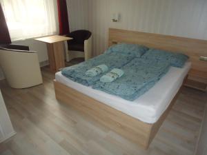 SzabadkígyósにあるDeutsches Hausのベッドルーム1室(青い掛け布団付きのベッド1台付)
