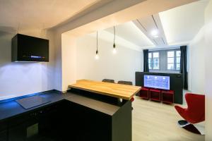 a living room with a table and a red chair at Apartment Bolzano in Bolzano