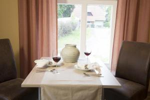 Stolpe auf Usedom的住宿－Der Westflügel Landrat Erdmann，一张桌子,上面放着两杯葡萄酒,还有一个窗口