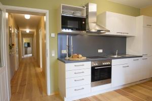 a kitchen with white cabinets and a stove top oven at Der Westflügel Ritter Florin in Stolpe auf Usedom