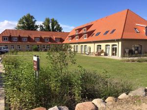 Der Landhof Strandhafer في Stolpe auf Usedom: مبنى كبير بسقف احمر على ميدان