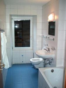 a white bathroom with a sink and a toilet at B&B Les Rochers 42 lits in Les Marécottes