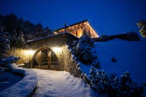 a house in the snow with lights on it at Skalny Zakątek z Grotą Solną na wyłączność in Łapsze Niżne