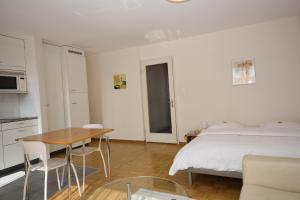 een slaapkamer met een bed en een tafel en een keuken bij PABS Résidences - Weinbergstrasse 68 (5MR) in Zürich