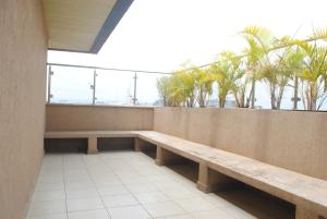 eine Bank auf einem Balkon mit Palmen im Hintergrund in der Unterkunft Westlands -Place studio apartment with a view in Nairobi