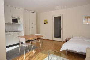 een keuken en een slaapkamer met een tafel en een bed bij PABS Résidences - Weinbergstrasse 68 (5MR) in Zürich
