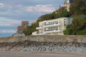 a white building on the side of a hill at Le Paquebot in Villerville +17 photos