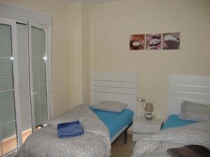 una piccola camera con due letti e una finestra di Residencial Duquesa 2049 a Manilva