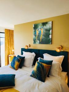 a bedroom with two large beds with colorful pillows at Le Paquebot in Villerville