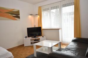 een woonkamer met een bank en een tv bij PABS Résidences - Mühlebachstrasse 50 (1M) in Zürich