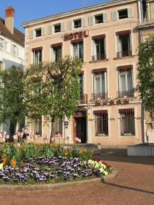 a building with a flower garden in front of it at Hotel Saint Jean in Chalon-sur-Saône