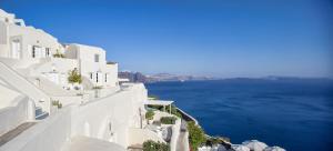 a view of the ocean from the side of a white building at Canaves Oia Suites - Small Luxury Hotels of the World in Oia
