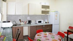 uma cozinha com uma mesa e um frigorífico branco em Roof em Sochi