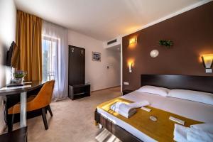 a hotel room with a bed and a desk at Hotel Nikola in Vodice