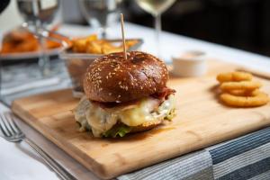 a sandwich on a wooden cutting board with french fries at Hotel Nikola in Vodice +14 photos