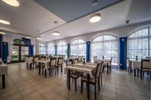 - une salle à manger avec des tables, des chaises et des fenêtres dans l'établissement Hotel Nikola, à Vodice