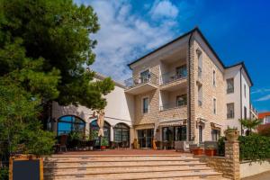 an exterior view of a large building with a patio at Hotel Nikola in Vodice