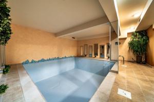 a large swimming pool in a building with a tile floor at Hotel Nikola in Vodice