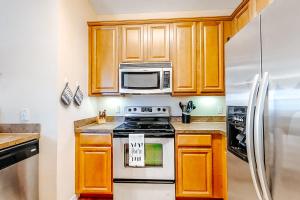 uma cozinha com armários de madeira, um fogão e um frigorífico em Magic St em Orlando