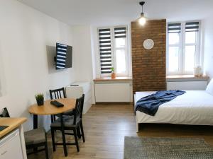 1 dormitorio con cama, mesa y escritorio en theApartments Radwańska en Lodz