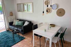 ein Wohnzimmer mit einem weißen Tisch und einem Sofa in der Unterkunft Die Seeblume - Ferienwohnung mit Pool und Seeblick in Bodman-Ludwigshafen