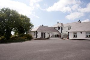 una casa blanca con una entrada delante de ella en Grovemount House, en Ennistymon