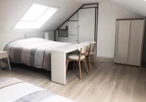 a bedroom with a bed and a desk with two chairs at Westhinder in Wenduine