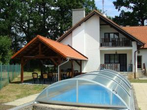 uma casa com piscina em frente a uma casa em Apartmány Dívčice em Dívčice