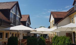eine Reihe von Gebäuden mit Sonnenschirmen im Innenhof in der Unterkunft Landgasthof Hotel Rittmayer in Hallerndorf