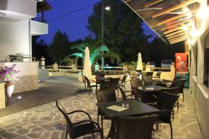 a restaurant patio with tables and chairs at night at Aphrodite in Keramoti