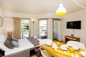 a living room with a bed and a dining room table at Colline Azur YourHostHelper in Cannes