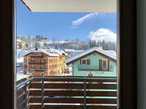 una ventana con vistas a una ciudad nevada en Residence Aurora en Lavarone