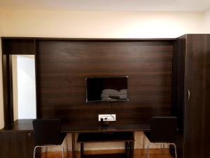 a room with a wooden wall with a tv on it at GRAND KODAI SR INN in Kodaikānāl