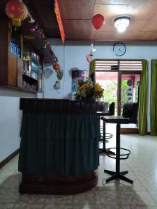 a bar in a room with a table and chairs at Hotel Olibert Parapat Ajibata Mitra RedDoorz in Parapat