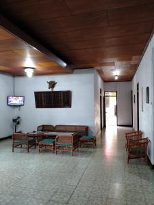 a waiting room with benches and a table in a building at Hotel Olibert Parapat Ajibata Mitra RedDoorz in Parapat