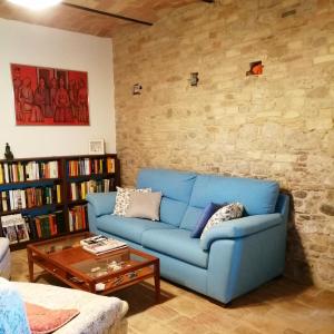 a blue couch in a living room with a brick wall at B&B Conca Del Pretore in Loreto Aprutino