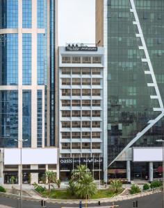 um edifício alto com uma placa na lateral em Oasis Hotel em Kuwait