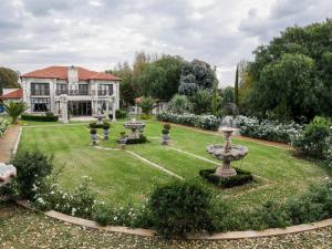 a house with a garden with a fountain in the yard at Tuscan Rose in Bloemfontein