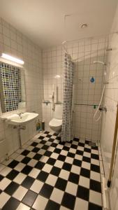 a bathroom with a black and white checkered floor at Danhostel Kalundborg in Kalundborg