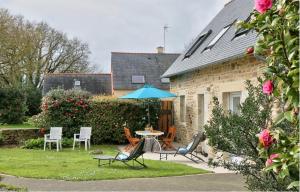 a patio with a table and chairs and an umbrella at Maison sur jardin clos au calme à la campagne et proche des plages in Mahalon