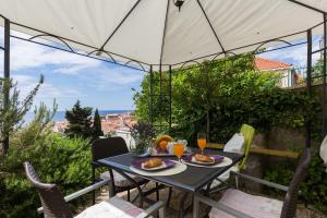 uma mesa com comida e bebidas num pátio em Apartment Purple Rain em Dubrovnik