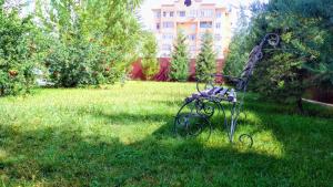 a metal bench sitting in the grass in a yard at Silk Way Boutique Hotel in Osh