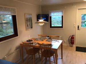 - une salle à manger avec une table et des chaises dans l'établissement Stuga i naturskönt område på västra Tjörn, à Säby