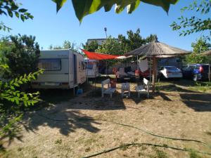 a campsite with an rv and a tent and chairs at Oz 2mai in 2 Mai