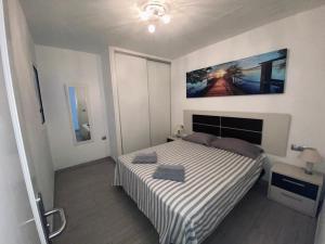 a bedroom with a bed and a painting on the wall at Luxury Two Bed Seaviews in Puerto del Carmen