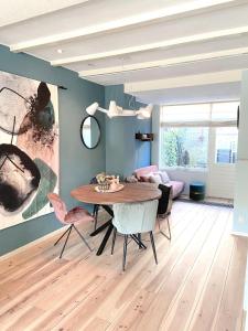 ein Wohnzimmer mit Esstisch und Stühlen in der Unterkunft Fijne vakantiehuizen 50 mtr van het strand in Egmond aan Zee