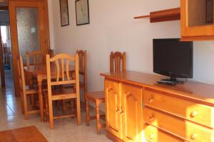 a dining room with a tv and a table with chairs at Apartamentos Turísticos Hawaii 6 in La Manga del Mar Menor