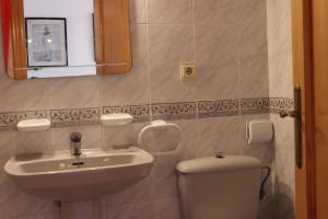 a bathroom with a sink and a toilet and a mirror at Apartamentos Turísticos Hawaii 6 in La Manga del Mar Menor
