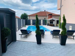 Un patio con sillas y una piscina. en Villa Balera, en Zadar