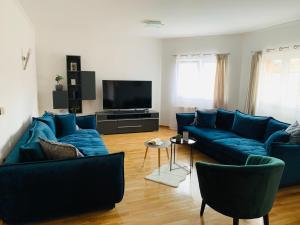 sala de estar con sofás azules y TV de pantalla plana en Villa Balera, en Zadar